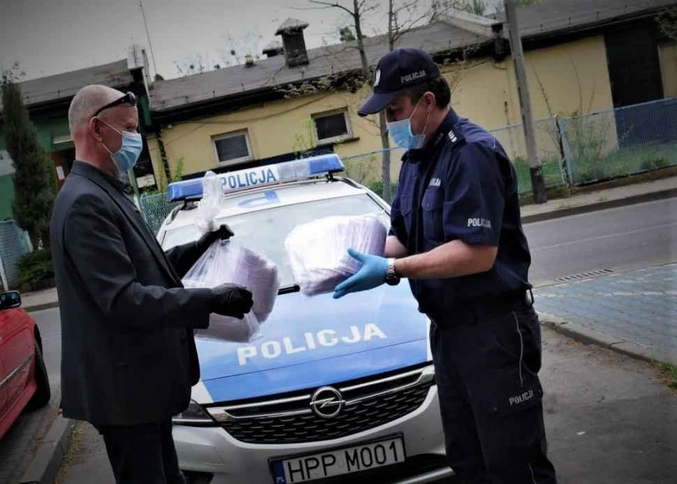 Policjanci przekazują maseczki mieszkańcom Powiatu Mikołowskiego