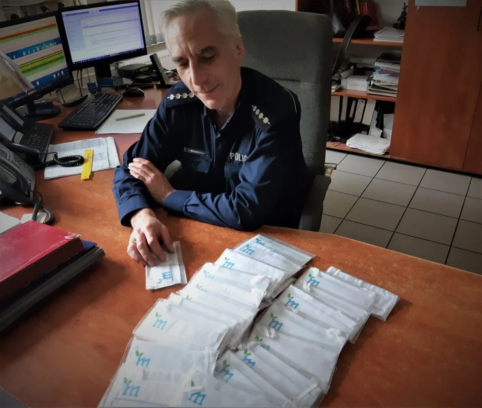 Policjanci przekazują maseczki mieszkańcom Powiatu Mikołowskiego