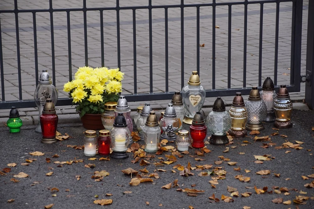 Rudzianie zapalają znicze pod zamkniętymi bramami cmentarzy