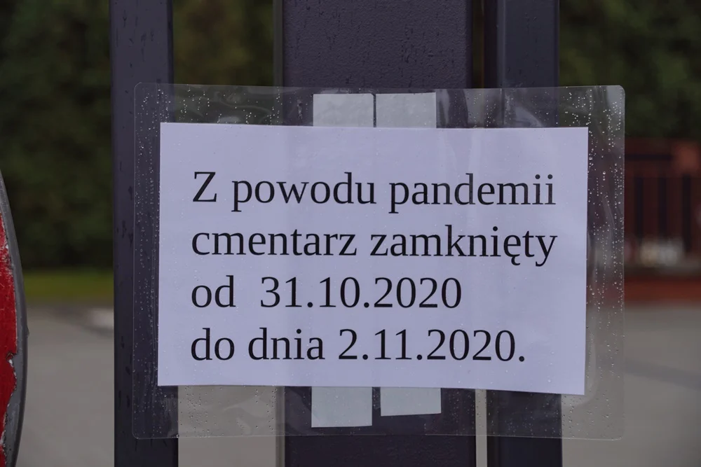 Rudzianie zapalają znicze pod zamkniętymi bramami cmentarzy