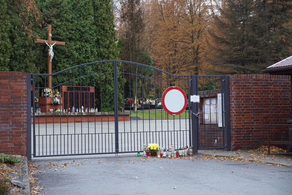 Rudzianie zapalają znicze pod zamkniętymi bramami cmentarzy