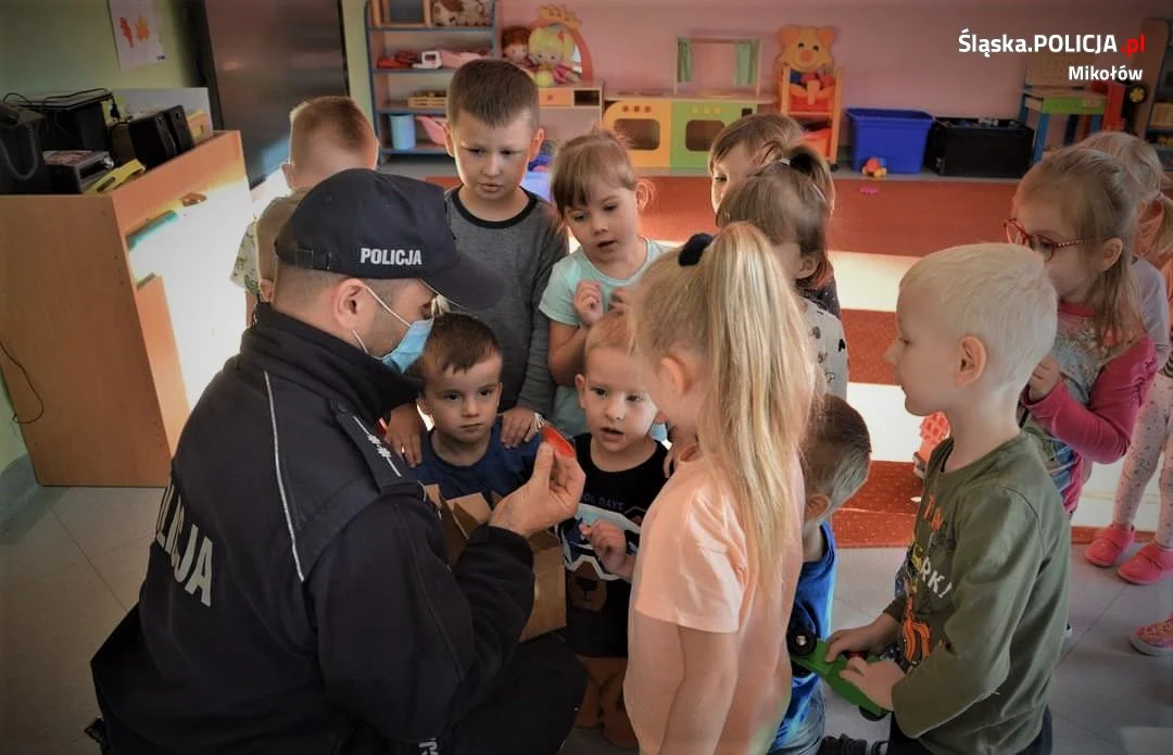 Dzielnicowy zachęca dzieci do bycia widocznym na drodze