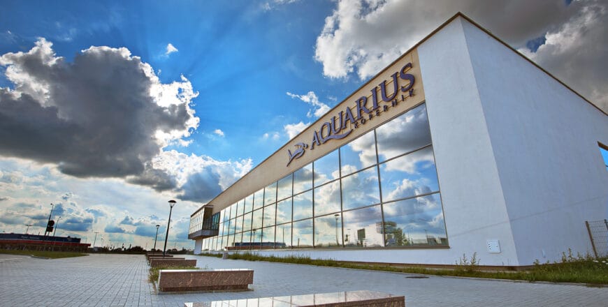 Nowoczesne carporty z instalacją fotowoltaiczną i magazynem energii przed Aquariusem