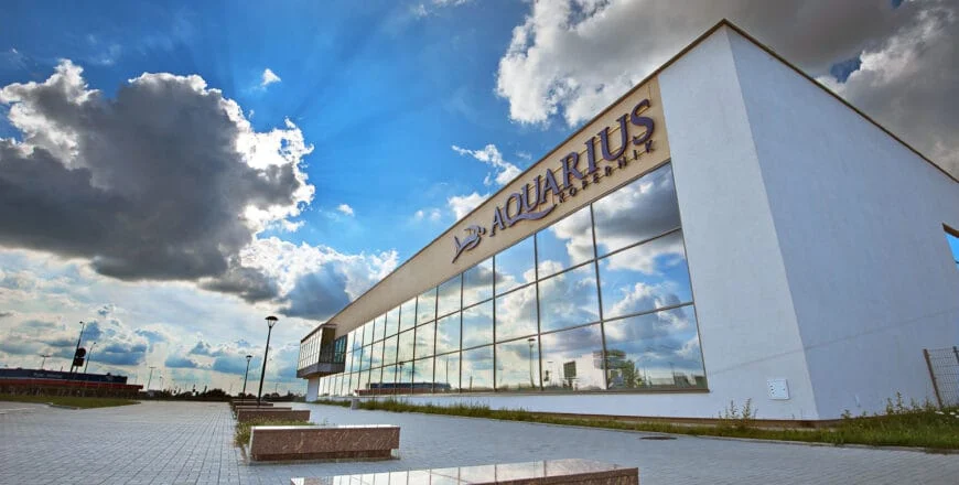 Nowoczesne carporty z instalacją fotowoltaiczną i magazynem energii przed Aquariusem